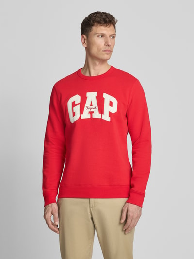 Männermodel trägt Sweatshirt mit Logo und Rundhalsausschnitt von GAP in Rot, Baumwoll-Mix, Regular-Fit, Logo, Nahaufnahme Oberkörper.
