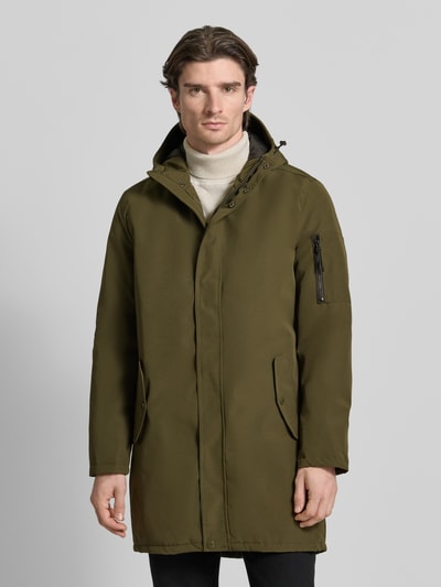 Męski model nosi Jacke mit Kapuze od MCNEAL, kolor oliwkowy, kieszenie z klapkami i zamkiem, regular fit, widok całej sylwetki z przodu.
