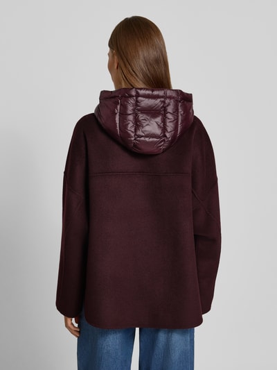 Frauenmodel trägt Jacke mit Kapuze von COMMA in Dunkelrot, lockere Passform, gesteppte Kapuze, Rückansicht, Ganzkörperansicht Rückansicht.