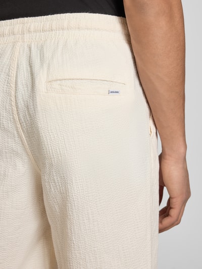 Männermodel trägt Shorts mit Strukturmuster Modell 'JAIDEN' von Jack & Jones, cremefarben, Material-Mix, Nahaufnahme Rückansicht.