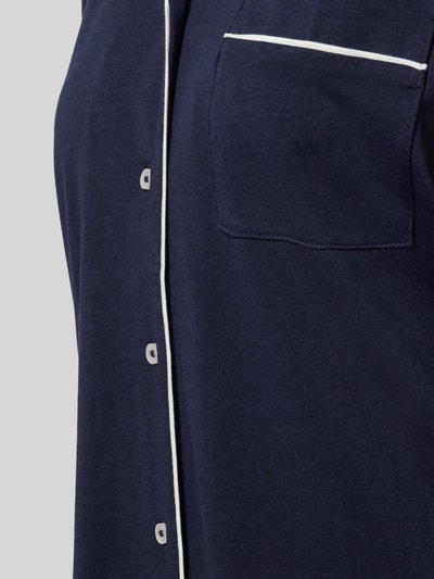 Frauenmodel trägt Regular Fit Pyjama-Oberteil mit Brusttasche von Christian Berg Woman aus Baumwoll-Modal-Mix in Dunkelblau, Nahaufnahme Oberkörper.