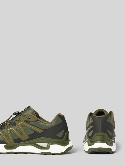 Produktfoto, Sneaker mit Logo-Detail Modell 'Roam' von Salomon in Olive und Schwarz, profilierte Sohle, abgerundete Passform, Herren, Absatzhöhe 3 cm, Schafthöhe 8 cm, Schaftweite 7 cm, strukturierte Materialien und markante Konturen.