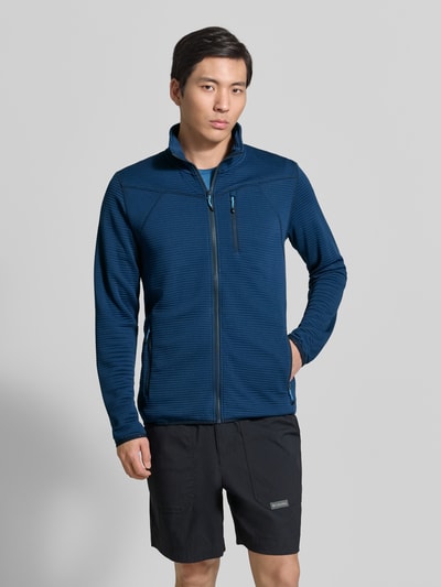 Männermodel trägt Regular Fit Fleecejacke mit Stehkragen Modell 'Berthold' von Icepeak in Dunkelblau mit Reißverschlusstaschen, Ganzkörperansicht von vorne.
