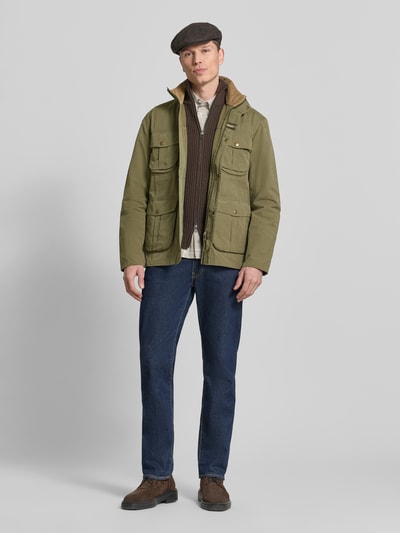 Männermodel trägt Regular Fit Jacke aus Baumwoll-Mix Modell 'SANDERLING' von Barbour in Grün, Optik: Unifarben, Ganzkörperansicht von vorne.
