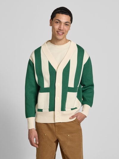Männermodel trägt Cardigan mit Streifenmuster und V-Ausschnitt von BLKVIS in Grün und Creme, Reine Baumwolle, Relaxed-Fit, Ganzkörperansicht von vorne.