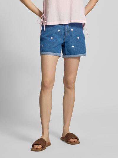 Frauenmodel trägt High Waist Jeansshorts aus reiner Baumwolle Modell 'VEGA' von Only, Denim in Blau mit Stickerei, Kontrastnähte und 5-Pocket-Design, Knopf und verdeckter Reißverschluss, Bundabschluss mit Umschlag, Ganzkörperansicht von vorne.