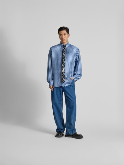 Männermodel trägt Relaxed Fit Freizeithemd aus Baumwolle von VETEMENTS in Blau mit Krawatte und Durchgehende Knopfleiste, Ganzkörperansicht von vorne. Rückenlänge 84 cm, Schulterbreite 58 cm, Ärmellänge 72 cm.
