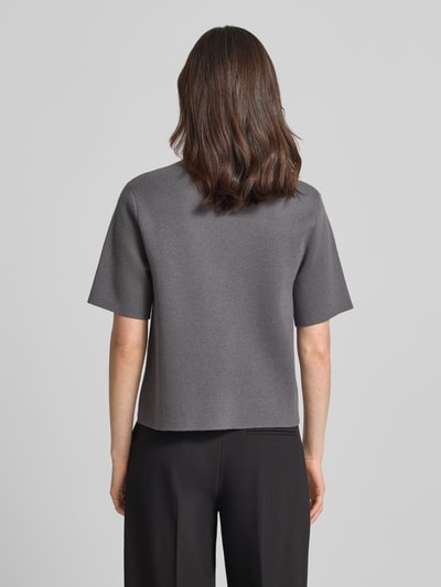 Frauenmodel trägt Strickshirt mit Polokragen Modell 'Tipolo' von Someday in Dunkelgrau, Material-Mix mit Viskose-Anteil, Gerader-Schnitt, kurze Knopfleiste, Rückenlänge 54 cm, Ärmellänge 25 cm, Ganzkörperansicht Rückansicht.
