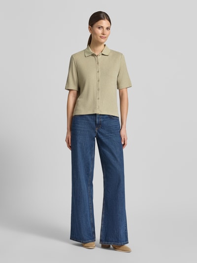 Frauenmodel trägt Regular Fit Poloshirt mit durchgehender Knopfleiste von OPUS in Beige, Viskose-Mix mit Stretch-Anteil, Ganzkörperansicht von vorne.