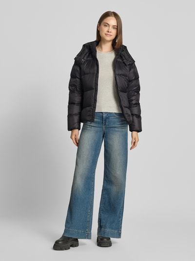 Frauenmodel trägt schwarze Steppjacke mit Label-Stitching Modell 'HYDRENALITE CITY DOWN' von The North Face, Mix mit Stretch-Anteil, Ganzkörperansicht von vorne.