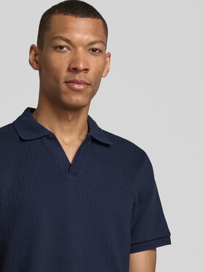 Männermodel trägt Regular Fit Strick-Poloshirt mit V-Ausschnitt von MCNEAL, Baumwoll-Mix mit Stretch-Anteil, Nahaufnahme Oberkörper.