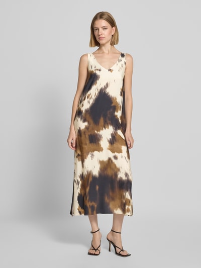 Frauenmodel trägt Midikleid aus Viskose im Allover-Look von Smith and Soul, cremefarben mit braunen und schwarzen Flecken, A-Linie, V-Ausschnitt, fließende Textur, Ganzkörperansicht von vorne.