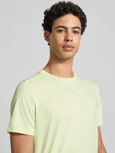 Männermodel trägt Regular Fit T-Shirt mit Logo-Print Modell 'Cloudspun' von PUMA PERFORMANCE in Hellgelb, Nahaufnahme Oberkörper. Herren T-Shirt mit Rundhalsausschnitt, Rückenlänge 65 cm bei Größe M.