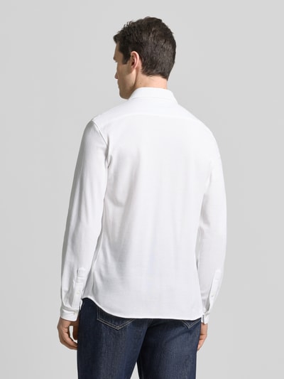 Männermodel trägt Slim Fit Freizeithemd aus reiner Baumwolle von Lacoste in Weiß, Optik: Unifarben, Materialverarbeitung: Piqué, Ganzkörperansicht Rückansicht.