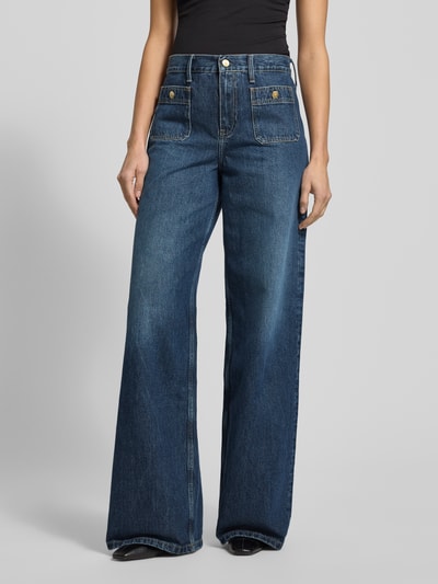 Frauenmodel trägt High-Rise Jeans aus reiner Baumwolle Modell 'DNM MINE 70 S WIDE LEG HW' von Tommy Hilfiger in Denim-Optik, Wide Leg Passform, Kontrastnähte, Label Patch, Logo-Stitching, Gürtelschlaufen, Knopf und verdeckter Reißverschluss, Eingrifftaschen und Gesäßtaschen, Materialstruktur sichtbar, Ganzkörperansicht von vorne.