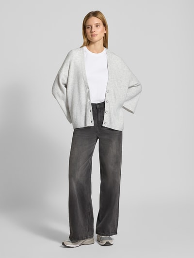 Frauenmodel trägt Relaxed Fit Cardigan mit Woll-Anteil Modell 'Damsville' von American Vintage in Strick-Optik, hellgrau, Ganzkörperansicht von vorne.