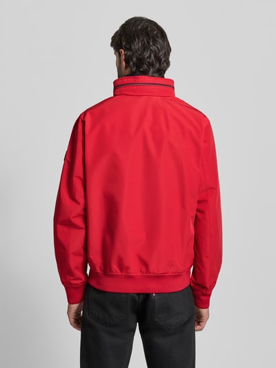 Männermodel trägt rote Regular Fit Jacke mit Kapuze Modell 'Como' von NAUTGÅRD, elastische Abschlüsse, Ganzkörperansicht Rückansicht.
