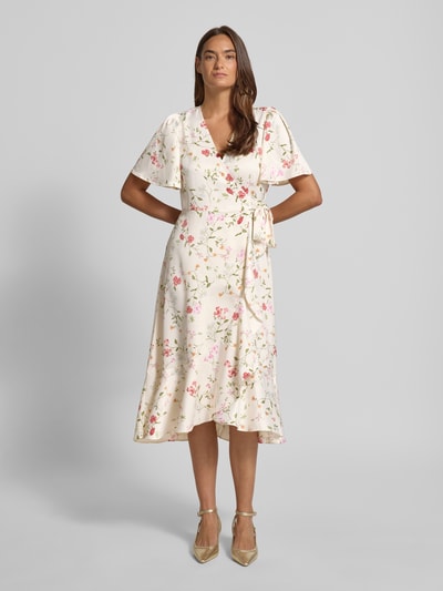 Vrouwenmodel draagt Cocktailjurk in wikkel-look model 'THEA' van YAS, stretch-materiaal, a-lijn, midi, allover bloemenprint, vooraanzicht hele lichaam.