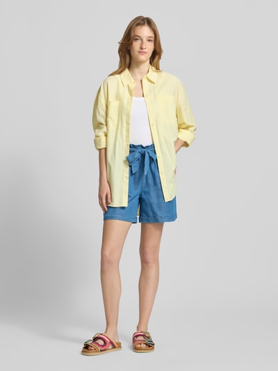Frauenmodel trägt Relaxed Fit Jeansshorts aus Baumwoll-Lyocell-Mix Modell 'BEA SMILLA' von Only in Denim-Optik mit Bindegürtel, Ganzkörperansicht von vorne.