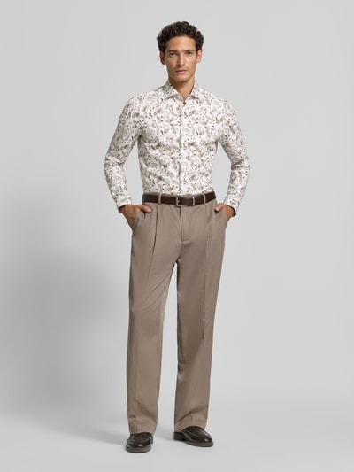 Männermodel trägt Body Fit Businesshemd aus Baumwoll-Mix von OLYMP mit floralem Muster, helle Farben, beige Hose, Ganzkörperansicht von vorne, Herren Businesshemd von OLYMP Level 5.