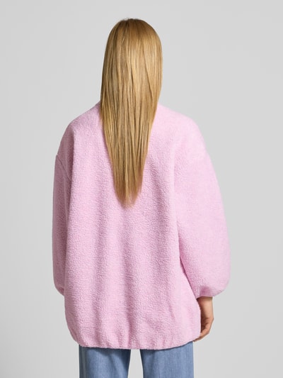 Vrouwenmodel draagt oversized jas met opstaande kraag, teddyfleece, kleur lichtroze, American Vintage, model 'HOKTOWN', rugaanzicht.