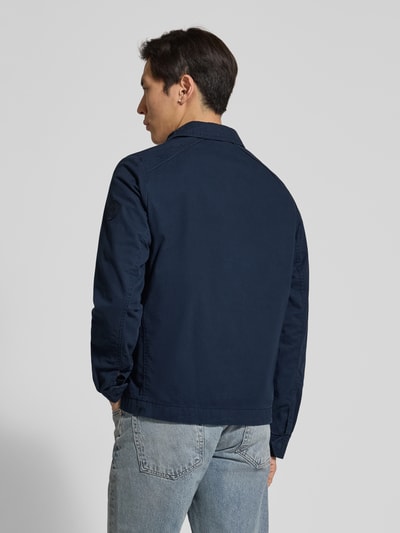 Männermodel trägt Regular Fit Hemdjacke aus reiner Baumwolle von Tom Tailor in Dunkelblau, unifarben, Twill-Struktur, Ganzkörperansicht Rückansicht.
