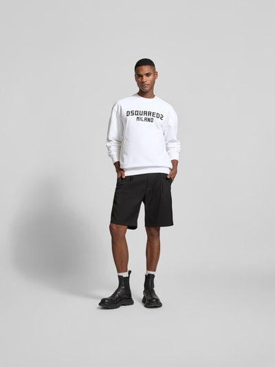 Männermodel trägt Cool Fit Sweatshirt aus reiner Baumwolle von Dsquared2 in Weiß mit schwarzem Label-Print, Ganzkörperansicht von vorne.