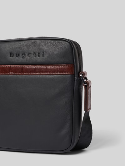Produktfoto, torba na ramię Umhängetasche mit Label-Detail Modell 'Corso Deluxe' von bugatti, czarna z brązowym detalem z logo, główna przegroda z zamkiem błyskawicznym, różne przegródki zapinane na zamek błyskawiczny, pasek na ramię, Szerokość w rozmiarze 1: 17 cm, Długość w rozmiarze 1: 19 cm, Głębokość w rozmiarze 1: 5 cm, długość paska na ramię w rozmiarze 1: 117 cm
