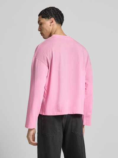 Männermodel trägt Relaxed Fit Longsleeve aus Baumwolle Modell 'Another Vintage' von ANOTHER COTTON LAB in Rosa, Rückenlänge 63 cm, Ganzkörperansicht Rückansicht.