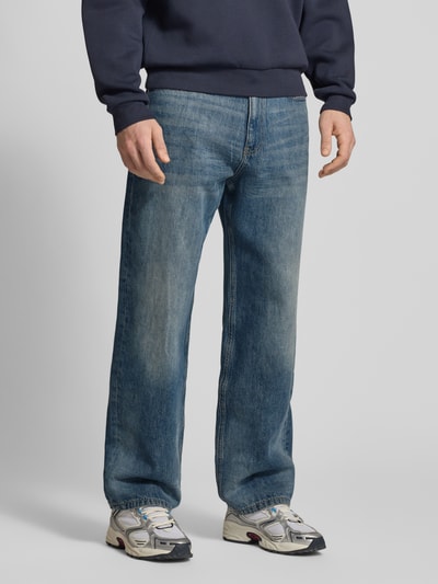 Männermodel trägt Jeans mit 5-Pocket-Design von REVIEW in Blau, gerader Schnitt, mittlere Waschung, Nahaufnahme Oberkörper bis Füße, Ganzkörperansicht von vorne.