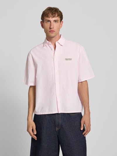 Männermodel trägt Regular Fit Freizeithemd mit 1/2-Arm von REVIEW aus Reine Baumwolle, blassrosa mit feinen Streifen, Kentkragen, Knopfleiste, Label-Detail, Ganzkörperansicht von vorne. Rückenlänge bei Größe M: 67 cm, Schulterbreite: 50 cm, Ärmellänge: 28 cm.