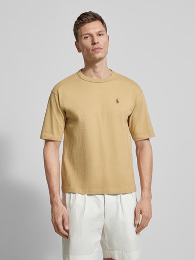 Männermodel trägt Regular Fit T-Shirt aus reiner Baumwolle von Polo Ralph Lauren in Beige, unifarben, Logo-Stitching, Ganzkörperansicht von vorne.
