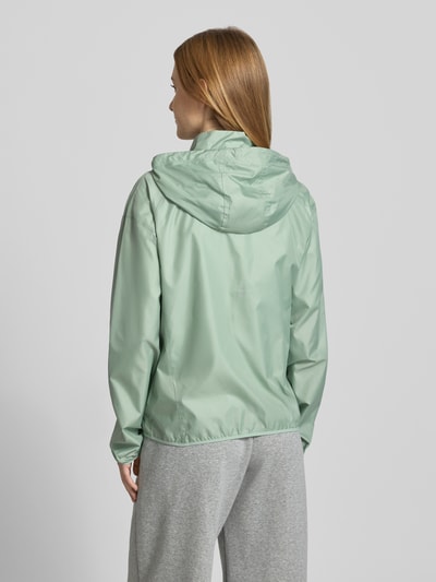 Frauenmodel trägt Regular Fit Jacke mit Stehkragen Modell 'Tempo' von NIKE TRAINING in hellem Mintgrün, Rückenansicht, glatte Textur, Kapuze mit Tunnelzug, Reißverschluss, Eingrifftaschen, elastische Abschlüsse, Maße bei Größe S: Rückenlänge 60 cm, Schulterbreite 54 cm, Brustweite 50 cm, Ärmellänge 59 cm.