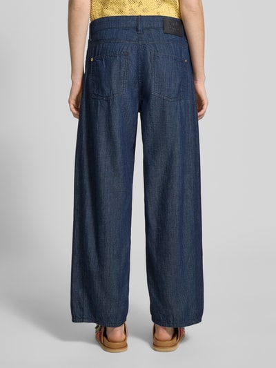 Frauenmodel trägt Barrel Fit Jeans aus reiner Baumwolle Modell 'ORIA' von Cambio in Denim-Optik mit Twill-Materialverarbeitung, 5-Pocket-Design, Label-Patch, Gürtelschlaufen und Knopf-Verschluss, Ganzkörperansicht Rückansicht.