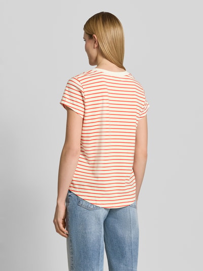 Frauenmodel trägt Damen T-Shirt mit V-Ausschnitt Modell 'Kala' von MOS MOSH im Baumwoll-Elasthan-Mix, Gerader-Schnitt, Rückansicht. Rückenlänge 63 cm bei Größe S, gestreiftes Design in Orange und Weiß, weiche Textur.
