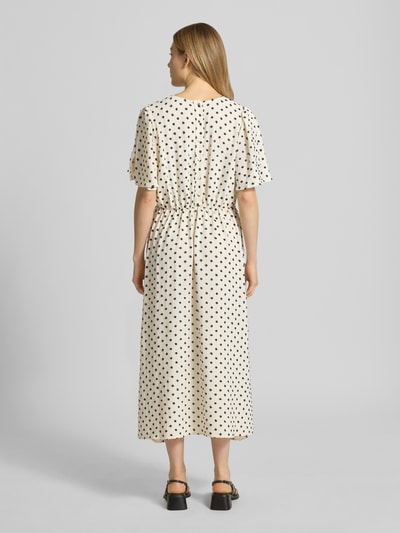 Modelka kobieca nosi Midikleid mit V-Ausschnitt Modell 'ZABBY' od ICHI, kremowy kolor, czarne kropki, luźna A-linia, całkowity nadruk, szerokie rękawy typu nietoperz, Szerokość w rozmiarze 36: 44 cm, długość tyłu: 124 cm, długość rękawa: 26 cm, widok całej sylwetki z tyłu.