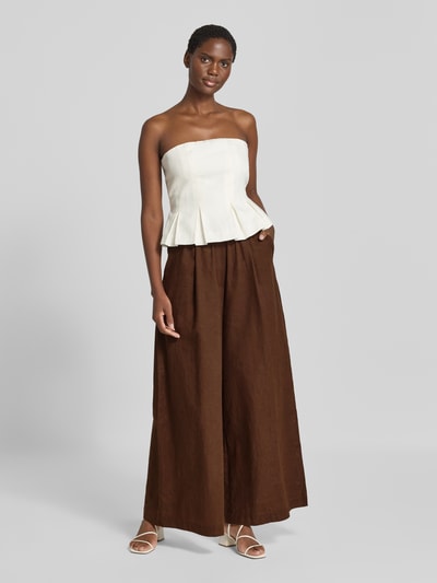 Frauenmodel trägt Wide Fit Leinen-Hose aus Leinen-Mix von Rich & Royal in Braun mit elastischem Bund und Bundfalten, Ganzkörperansicht von vorne.