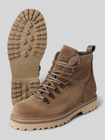 Produktfoto, Boots aus echtem Leder mit Strukturmuster von Woolrich in Braun mit abgerundeter Passform, Logo-Detail, deutliche Textur