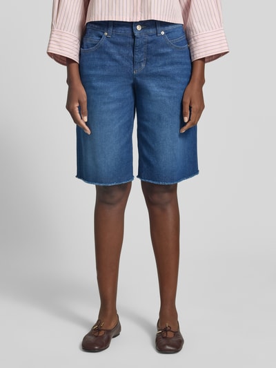 Frauenmodel trägt Jeansshorts mit Fransen Modell 'Rich' von MAC aus Baumwoll-Elasthan-Mix, Relaxed-Fit, Eingrifftaschen, mittleres Blau, Ganzkörperansicht von vorne. Bundweite bei Größe 36: 41 cm, Innenbeinlänge 33 cm.