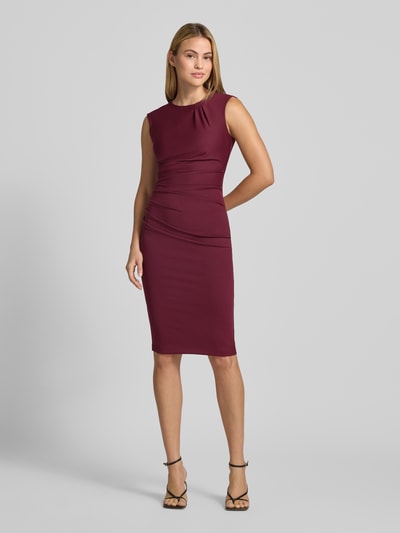 Frauenmodel trägt Cocktailkleid mit Raffungen von Rinascimento in Dunkelrot, taillierte Passform, knielang, glatte Textur, Ganzkörperansicht von vorne, Material-Mix mit Stretch-Anteil, ärmellos, Rundhalsausschnitt, Rückseitiger Reißverschluss.