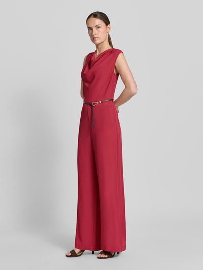 Vrouwenmodel draagt Jumpsuit met Wasserfall-Ausschnitt en riem van Jake*s Collection in rood materiaalmix met stretch, regular fit, ganzkörperansicht van voren. Ruglengte maat 36: 152 cm, borstwijdte: 44 cm, totale lengte: 148 cm, binnenbeenlengte: 81 cm.
