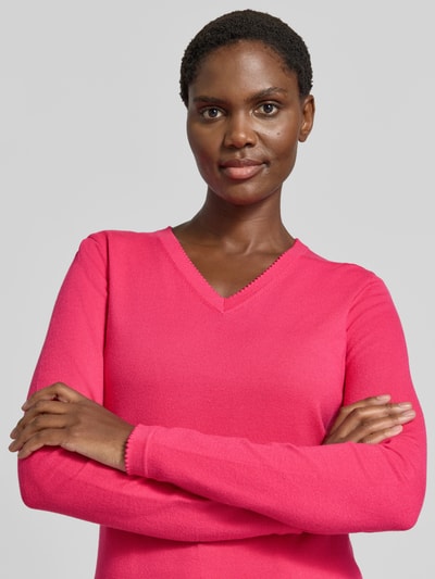 Frauenmodel trägt Pullover aus Viskose-Mix mit V-Ausschnitt von Christian Berg Woman, pink, gerader Schnitt, Nahaufnahme Oberkörper.