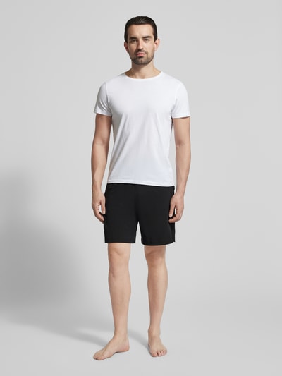 Männermodel trägt Regular Fit Sweatshorts aus Baumwoll-Mix von Tommy Hilfiger, unifarben, Logo-Detail, seitliche Taschen, Ganzkörperansicht von vorne
