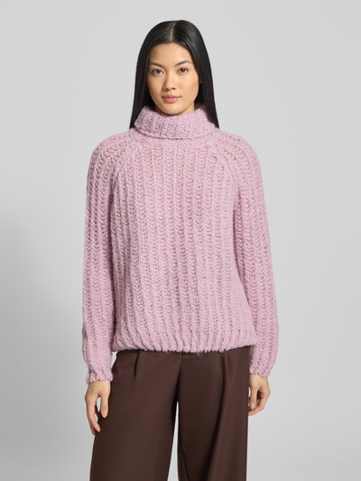 Frauenmodel trägt Strickpullover mit Rollkragen von Smith and Soul in Hellrosa, grob gestrickte Struktur, lockerer Schnitt, gerippte Abschlüsse, Material-Mix mit Alpaka-Anteil, Ganzkörperansicht von vorne.