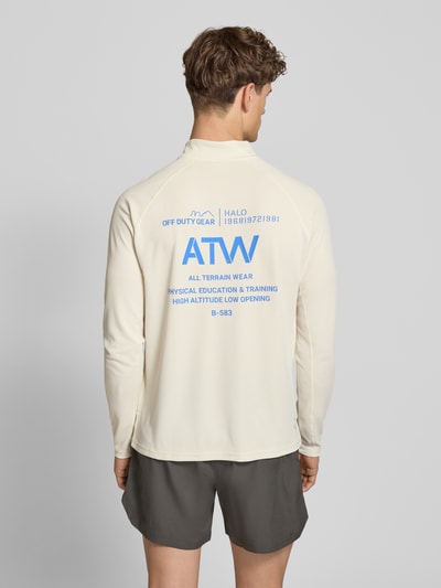 Mannenmodel draagt Longsleeve met Stehkragen en Reißverschluss Modell 'SORONA' van HALO in crème met blauwe labelprint, regular fit, ruglengte 70 cm bij maat M, productfoto, ganzkörperansicht rückansicht.