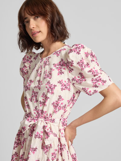Frauenmodel trägt Minikleid im Allover-Look mit Bindegürtel von Neo Noir, cremefarben mit pinken Blumen, reine Baumwolle, Rundhalsausschnitt, Nahaufnahme Oberkörper
