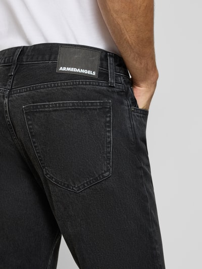 Männermodel trägt dunkelgraue Straight Fit Jeans aus reiner Baumwolle Modell 'MAADOX' von ARMEDANGELS, Nahaufnahme Rückansicht, Herren Straight Fit Jeans von ARMEDANGELS.