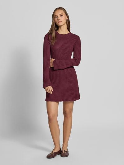 Frauenmodel trägt Eng anliegendes Freizeitkleid aus Viskose-Mix Modell 'MICHELLA' von ONLY in Dunkelrot, gerippte Struktur, Ganzkörperansicht von vorne, Damen Strickkleid von ONLY.