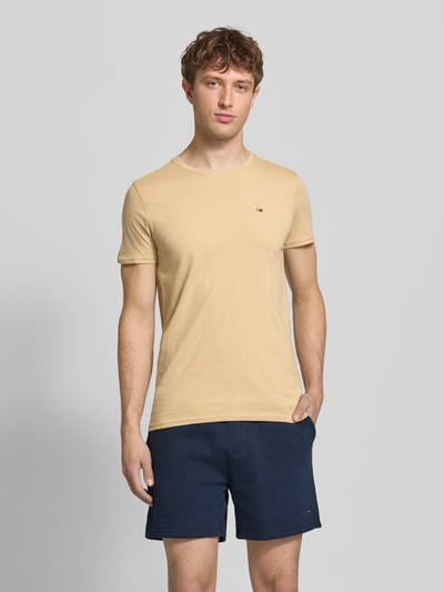 Männermodel trägt Regular Fit T-Shirt aus reiner Baumwolle von Tommy Jeans, Optik: Unifarben, Logo-Stitching, Ganzkörperansicht von vorne.