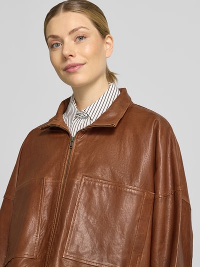 Vrouwenmodel draagt DRYKORN Lederjacke met Reißverschluss Modell 'ELSTOW' van echt leer, relaxed fit, opstaande kraag, bruin, ritssluiting, Nahaufnahme bovenlichaam.